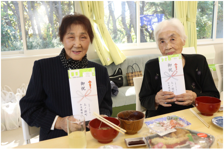 敬老の日の記念品を手にする町民
